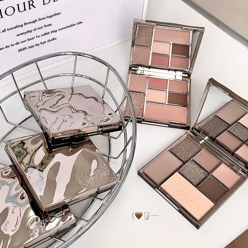 Makeup palettes with a decorative box on a white surface