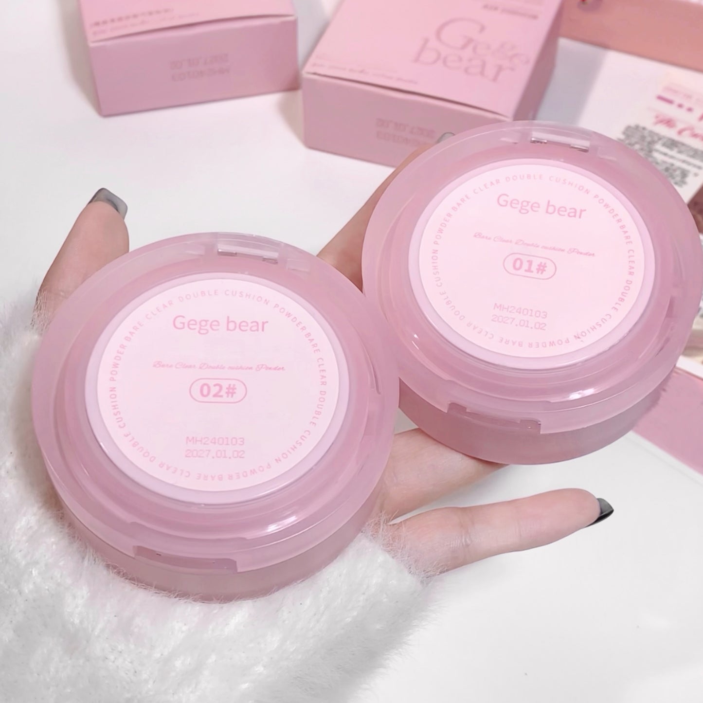 Two pink compact mirrors with 'Gego bear' branding held by a hand on a white background.