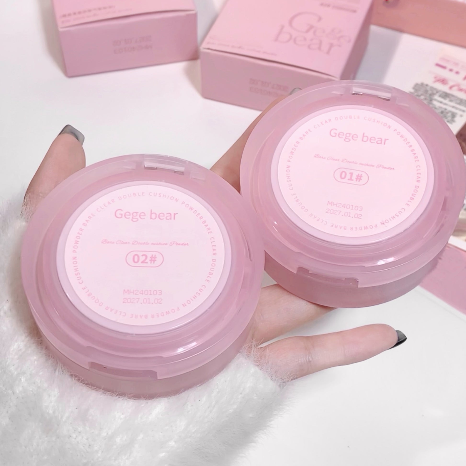Two pink compact mirrors with 'Gego bear' branding held by a hand on a white background.
