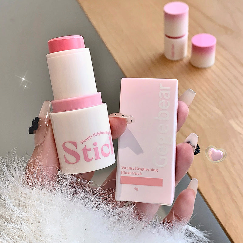 Hand holding a blush stick and its packaging with a blurred background