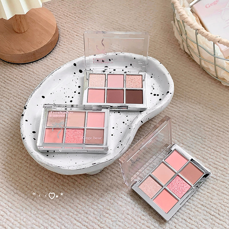 Makeup palettes with pink and brown shades on a textured surface