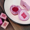 Pink heart-shaped lip jelly with 'GEGE BEAR' branding on a white plate.