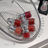 Red crystal necklace with silver accents on a metal stand, branded 'GEGE BEAR'.