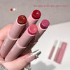Set of lipsticks held by a hand with a neutral background
