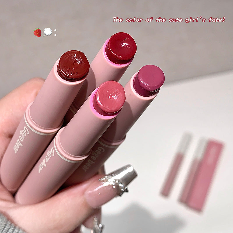 Set of lipsticks held by a hand with a neutral background