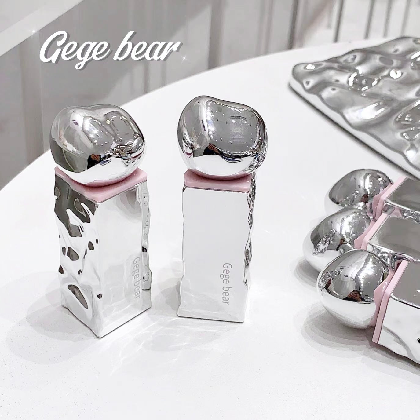 Silver dental models with pink bases on a white surface, branded 'Gege bear'.
