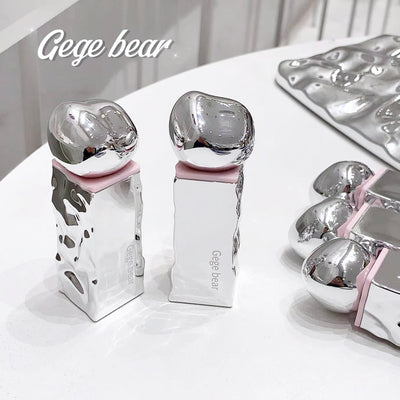 Silver dental models with pink bases on a white surface, branded 'Gege bear'.