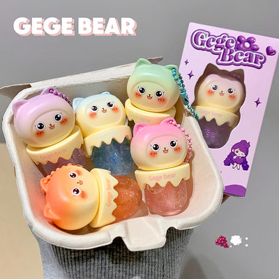 Set of cute GEGE BEAR figurines in a display case with a branded card in the background.