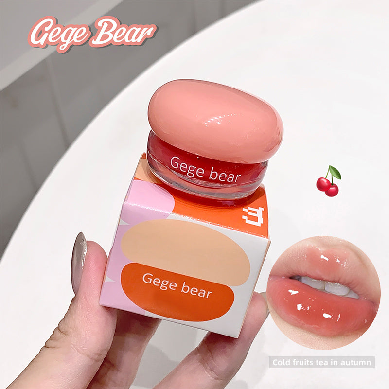 Gege Bear lip balm with packaging held by a hand, close-up of lips with product applied.