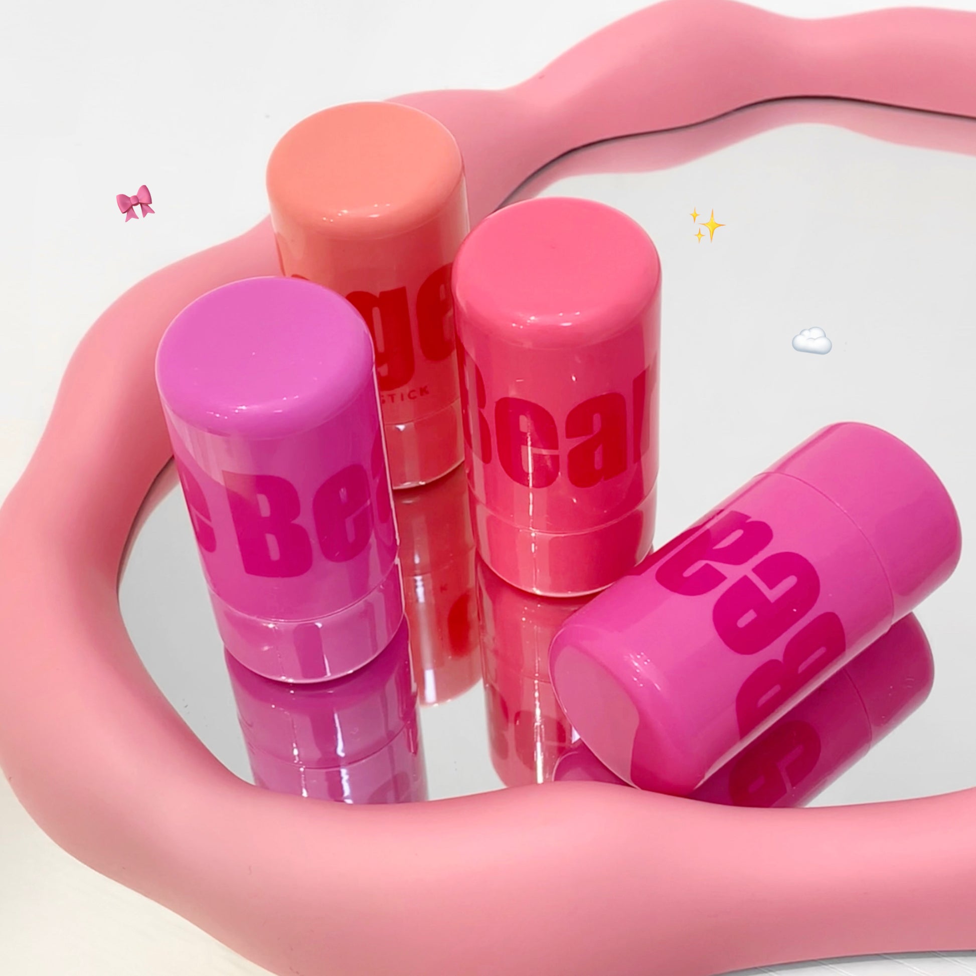 Pink lip balms with 'Bebe' branding on a pink holder against a white background