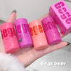 Hand holding pink Gege bear blush sticks with packaging on a light background