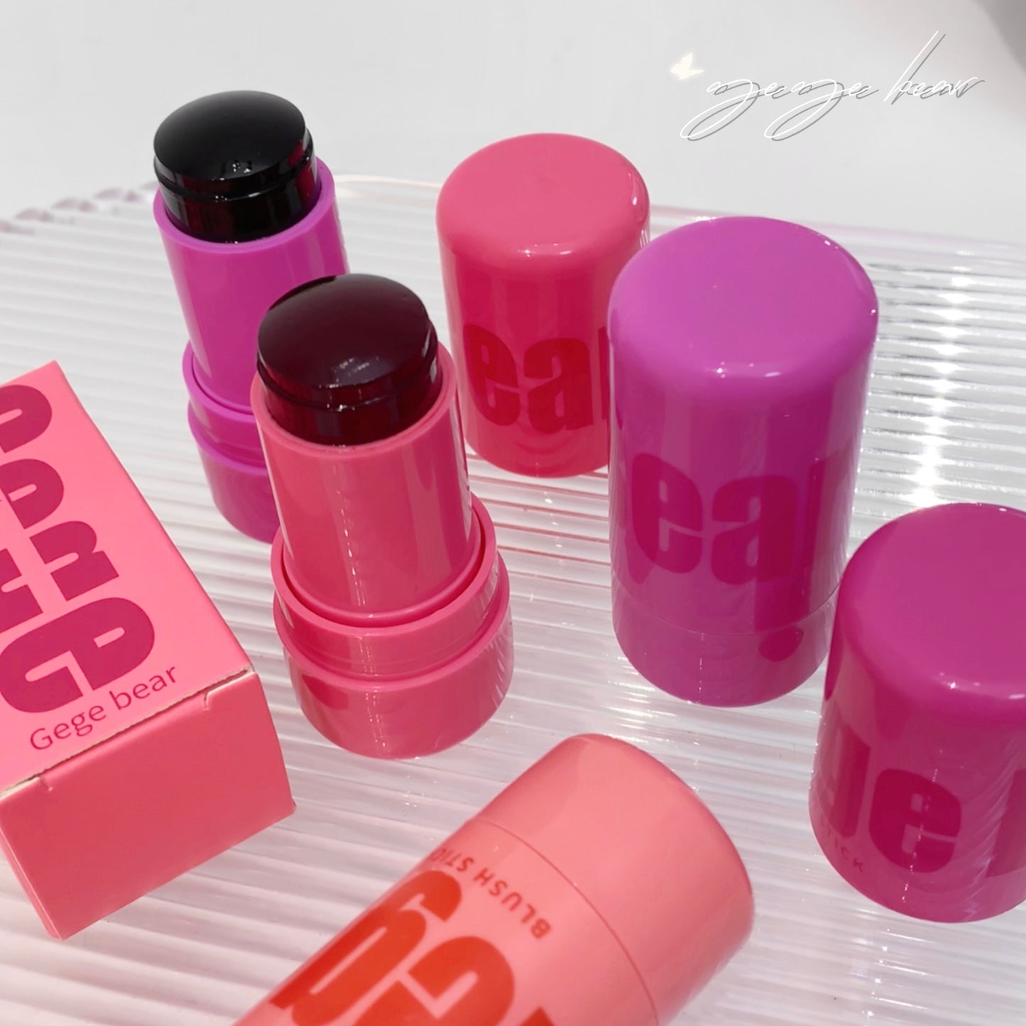 Pink lip balm sticks with visible brand name on a white surface
