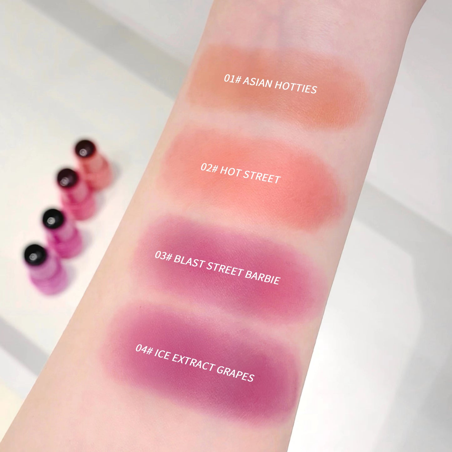 Lipstick swatches on a person's arm with color names and codes.