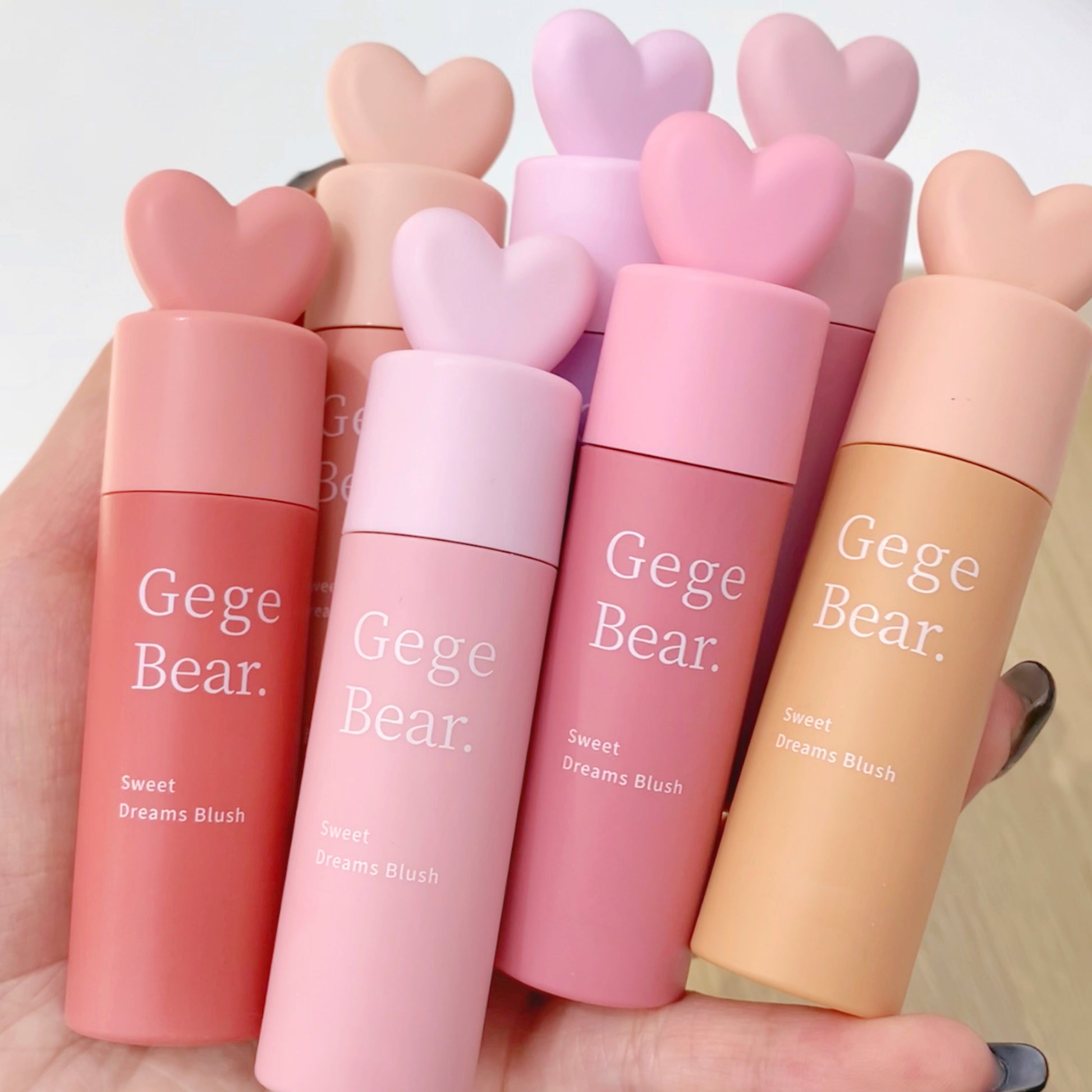 Set of Gege Bear blushes in various shades held by a hand against a neutral background