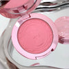 Pink makeup compact with a mirror in the background