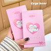 Two pink lip balm packages with a cartoon bear design held by a hand.