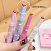 Four colorful lip-shaped crayons held by a hand with a blurred background