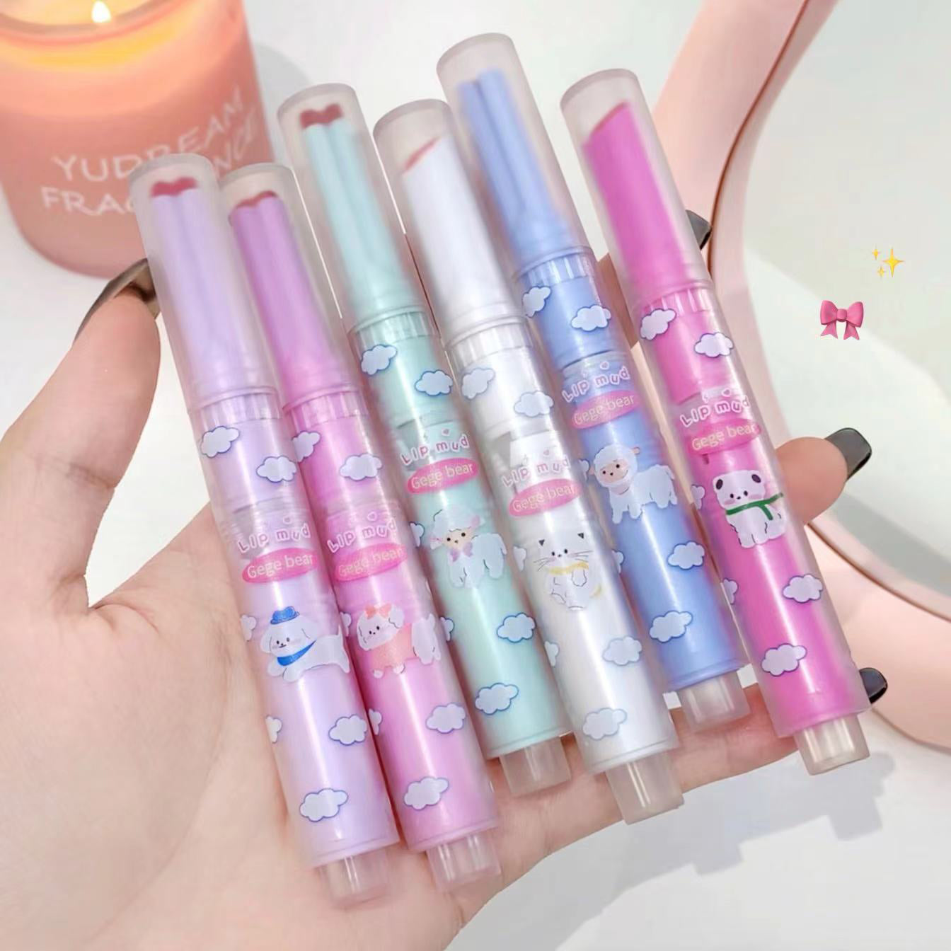 Set of colorful cartoon-themed pens held in a hand with a soft focus background.