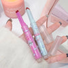 Two colorful lip balms with cartoon designs held by a hand on a light background.