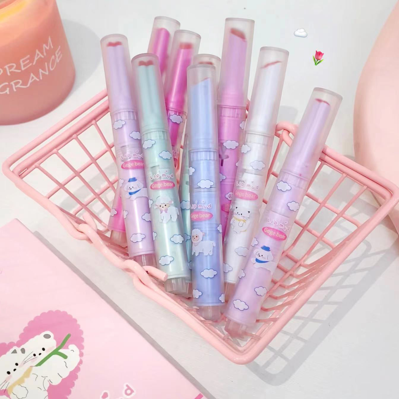 Set of pastel-colored pens with cartoon designs in a pink holder on a light background