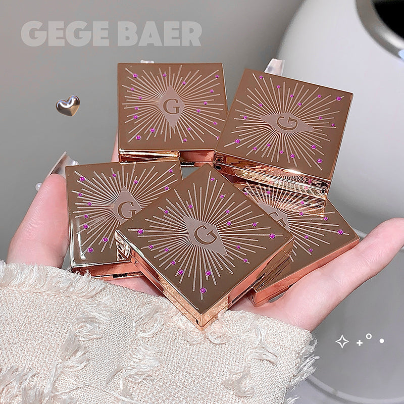 Bronze makeup compact cases with 'G' logo held in a hand, brand 'GEGE BAER' visible.