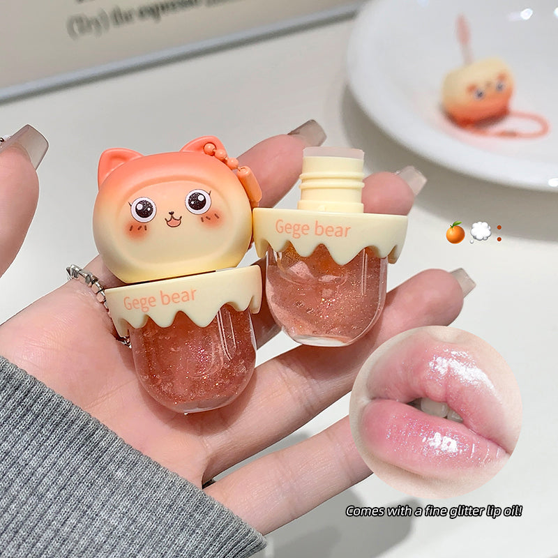 Small bear-shaped lip gloss held by a hand with a blurred background
