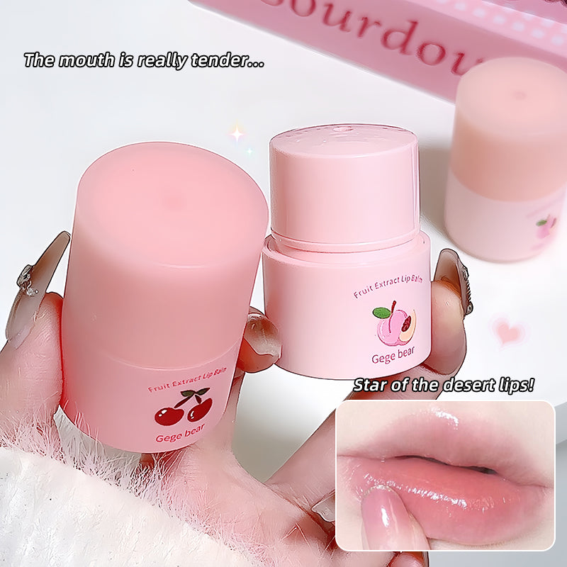 Pink lip balm with cherry design held by a hand, close-up of lips with product applied.