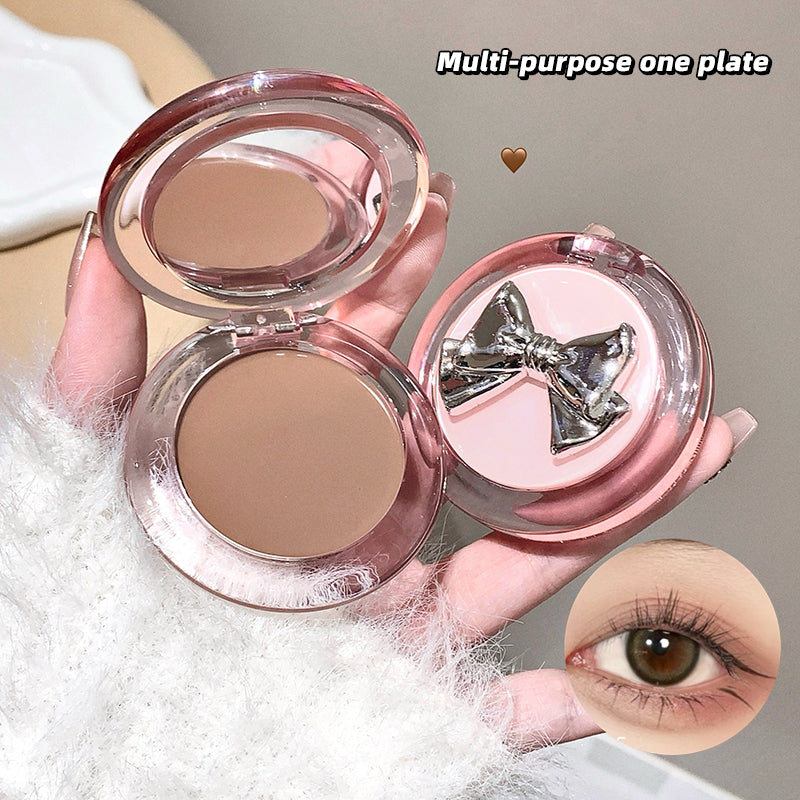 Compact powder with a bow design on a neutral background