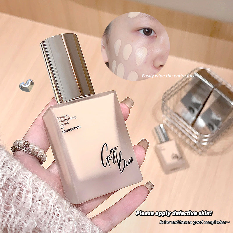 Foundation bottle held by a hand with a blurred background