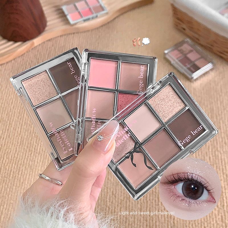 Makeup palettes with 'Gege bear' branding on a beige surface, with a hand holding one palette.