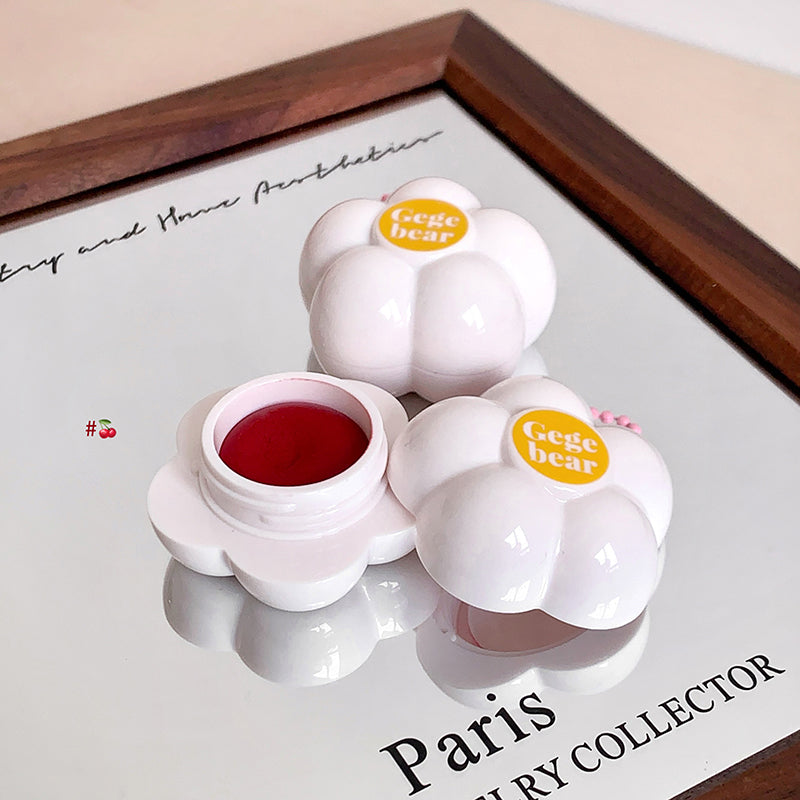 White floral-shaped containers with red liquid on a white tray with 'Paris' text