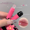 Pink lip balm with silicone brush held by a hand, showing before and after opening the lid.