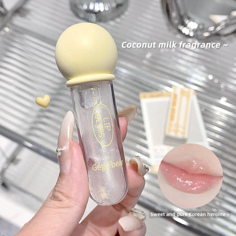 Lip balm with coconut milk fragrance held by a hand, with a blurred background.