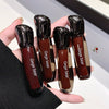 Four lip glosses with 'Gege bear' branding held in a hand against a neutral background.