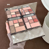 Makeup palette with various shades held by a hand on a brown surface
