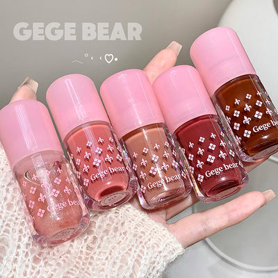 Set of Gege Bear nail polishes held in a hand with a white lace background