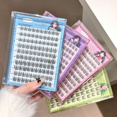 Eyelash extensions in clear cases with colorful packaging held by a hand.
