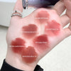 Hand with six different shades of lipstick swatched on a white background