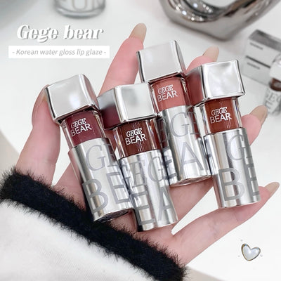 Hand holding four 'Gege Bear' lip glosses with a blurred background
