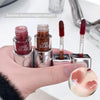 Hand holding GEGE BEAR lip products with a peach slice on a white background