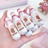 Set of small bottles with bear designs held in a hand