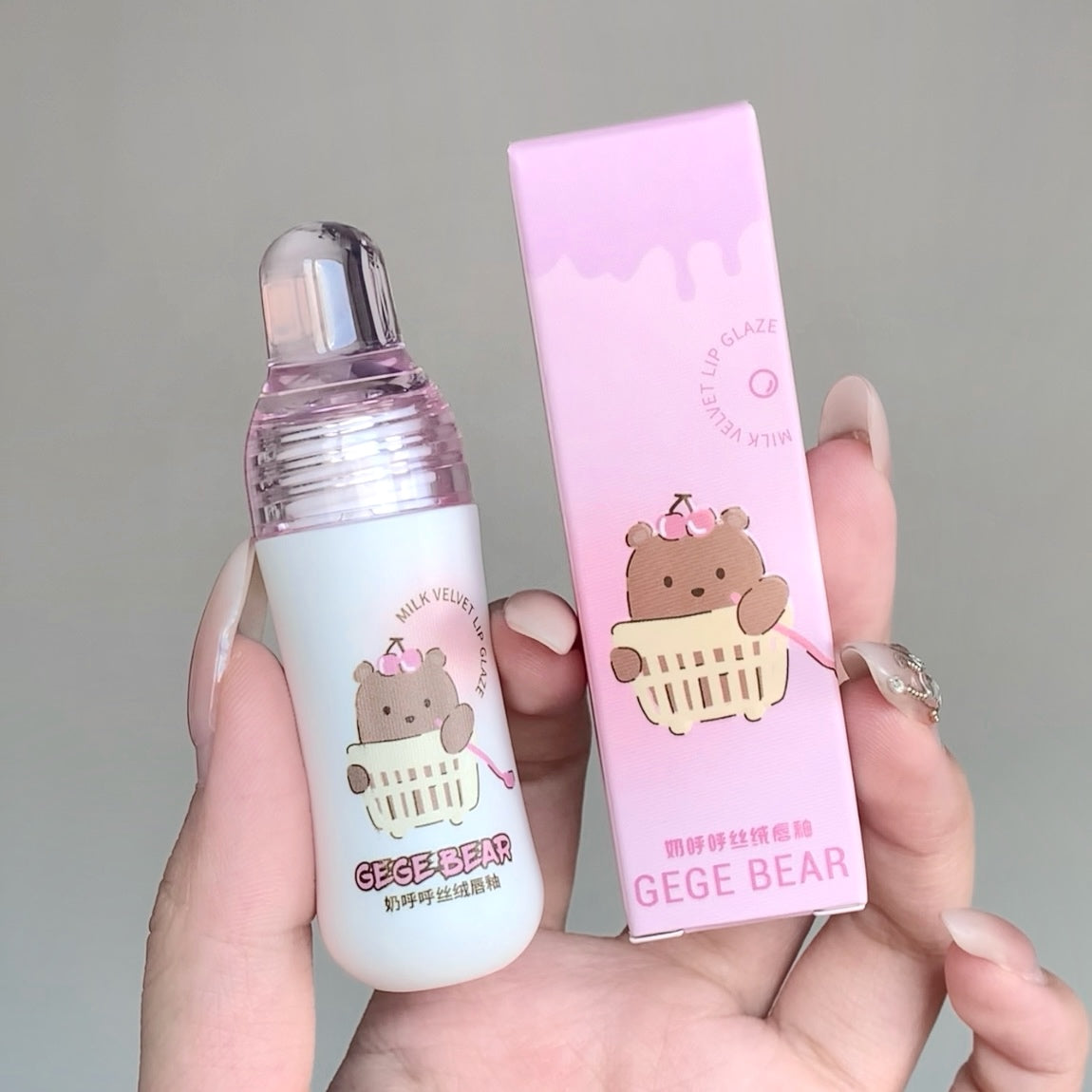 Small bottle and pink packaging with 'GEGE BEAR' design held by a hand against a gray background.