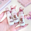 Three small bottles with bear illustrations held in a hand against a light background