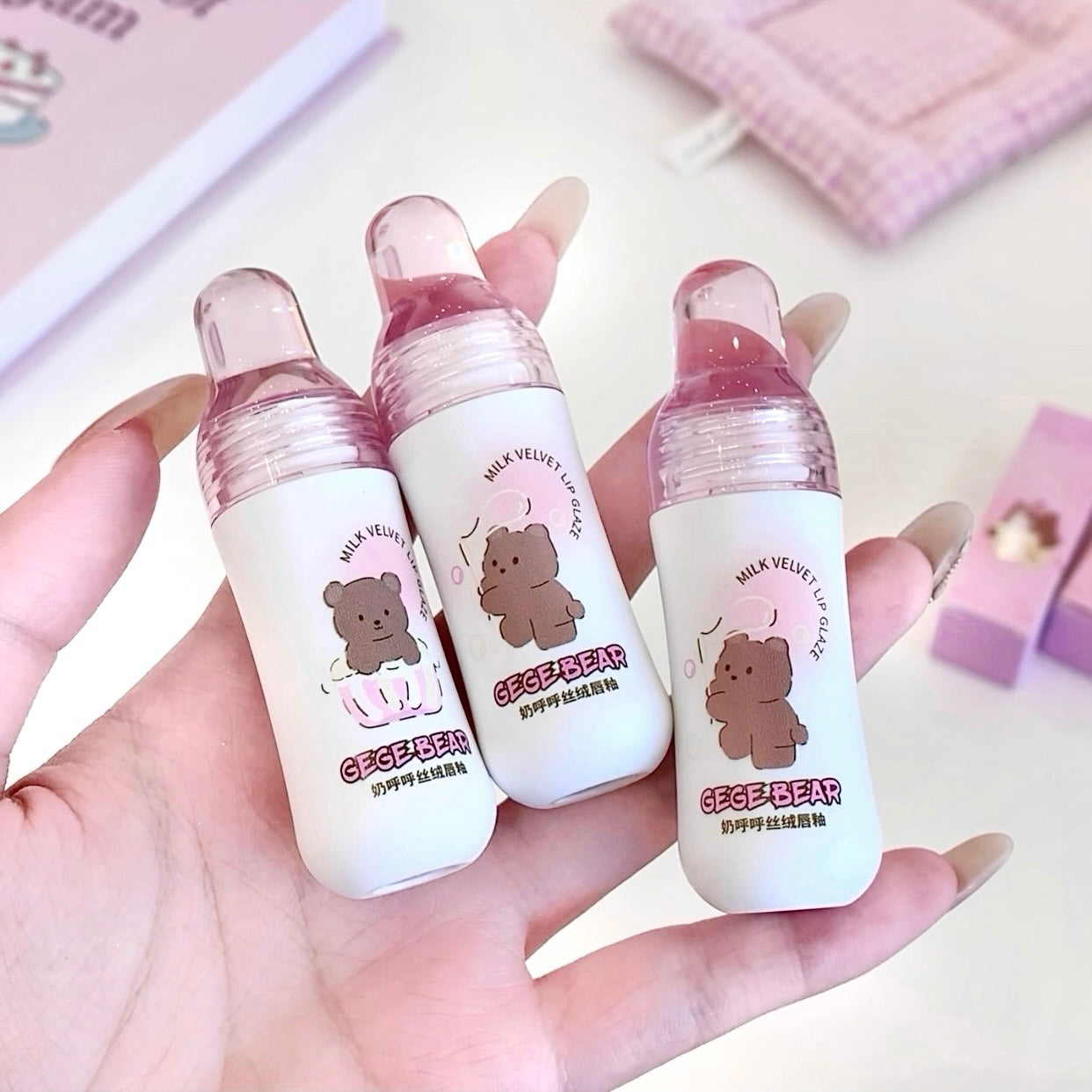 Three small bottles with bear illustrations held in a hand against a light background