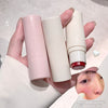 Three lipsticks in pink, white, and red held by a hand against a light background.