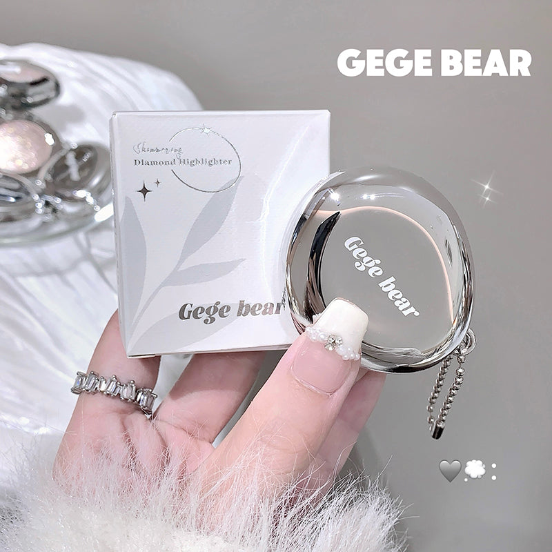Compact mirror with 'GEGE BEAR' branding held by a hand, with packaging in the background.