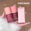 Two lip and cheek balms and their packaging held by a hand on a textured surface with 'GEGE BEAR' branding.