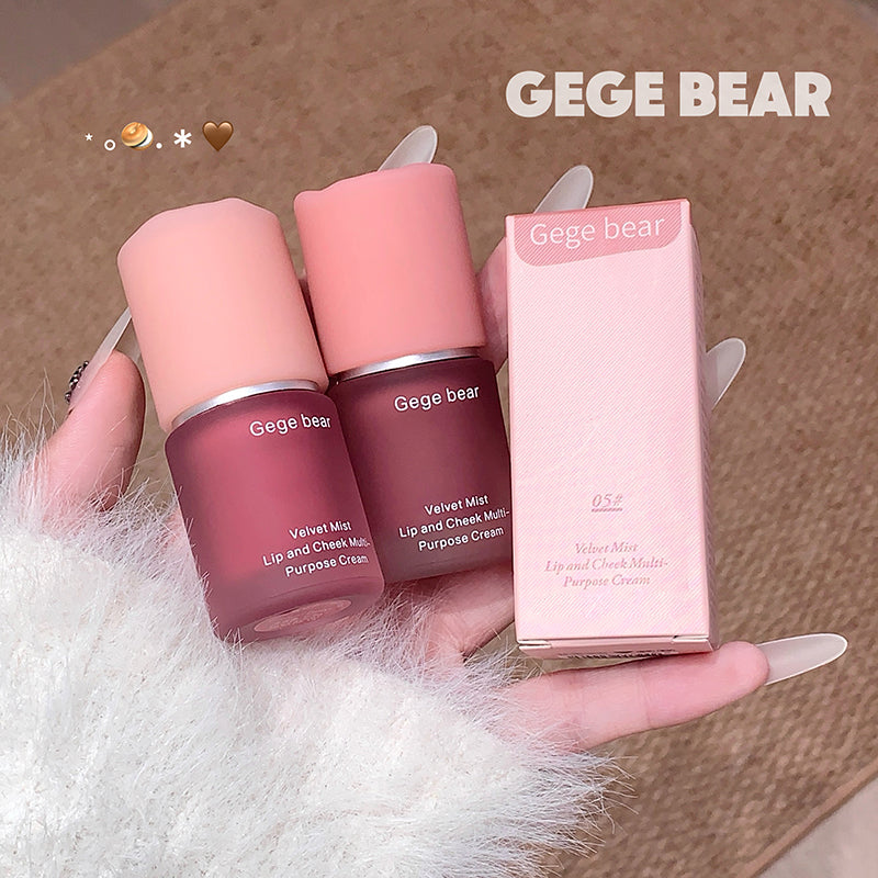 Two lip and cheek balms and their packaging held by a hand on a textured surface with 'GEGE BEAR' branding.