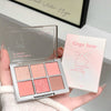 Makeup palette with four shades held by a hand, next to its packaging, on a light background.