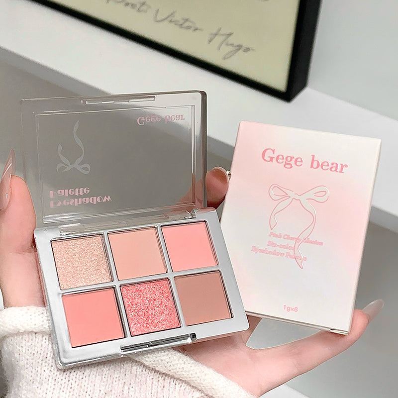 Makeup palette with four shades held by a hand, next to its packaging, on a light background.